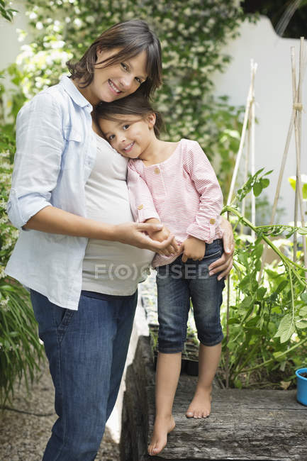 Grossesse mère et fille étreignant à l'extérieur — Photo de stock