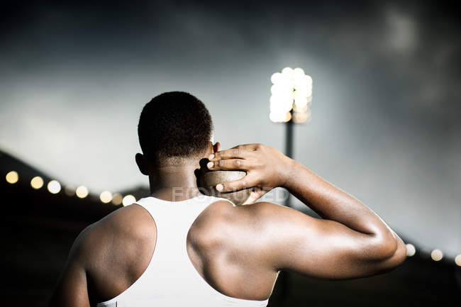 Track and field athlete holding shot put — Stock Photo