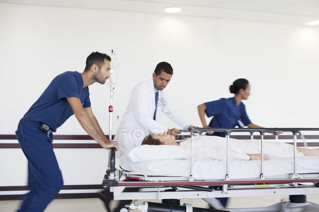 Personale ospedaliero correre paziente in sala operatoria — Foto stock