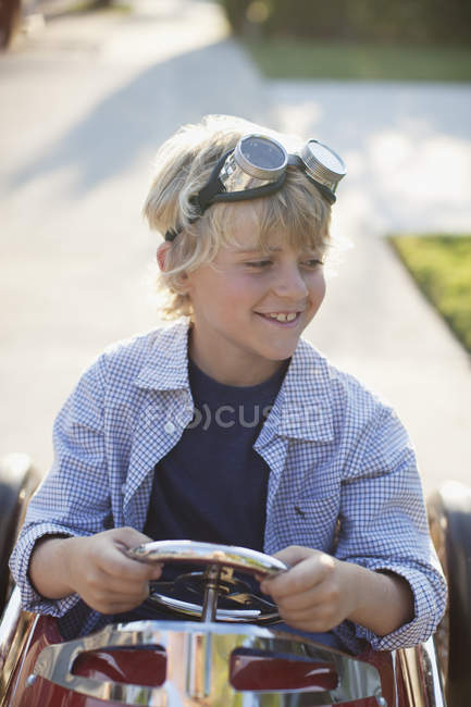 Улыбающийся мальчик, играющий в го-карт — стоковое фото