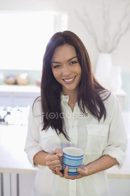 Donna sorridente con tazza di caffè — Foto stock