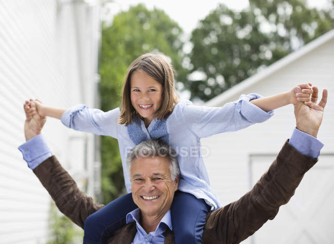 Homme portant sa petite-fille sur les épaules — Photo de stock