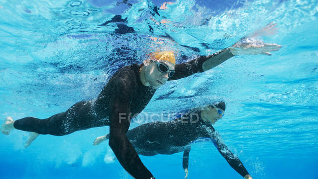 Selbstbewusste und starke Triathleten in Neoprenanzügen unter Wasser — Stockfoto