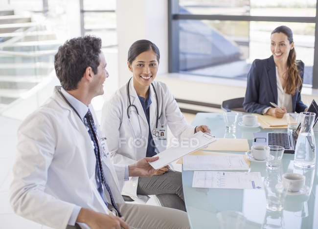 Médicos y empresarias conversando en reunión - foto de stock