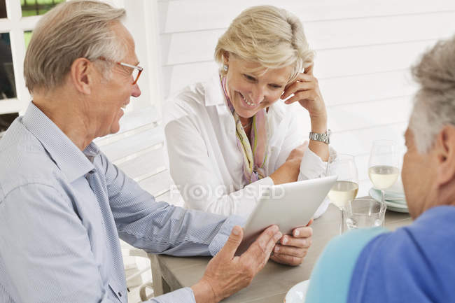 Couple utilisant une tablette numérique à la table à l'extérieur — Photo de stock