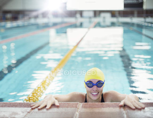 Porträt einer lächelnden Schwimmerin am Beckenrand — Stockfoto