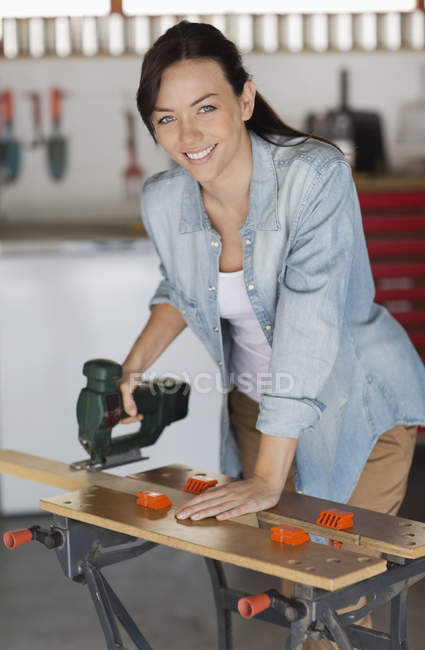 Hábil mujer caucásica trabajando en el taller - foto de stock
