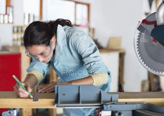 Hábil mujer caucásica trabajando en el taller - foto de stock