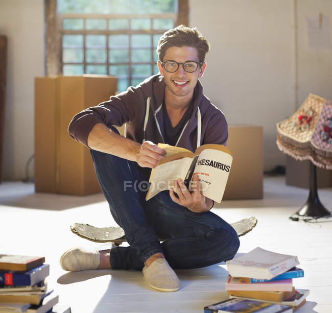 Jovem homem feliz lendo em nova casa — Fotografia de Stock