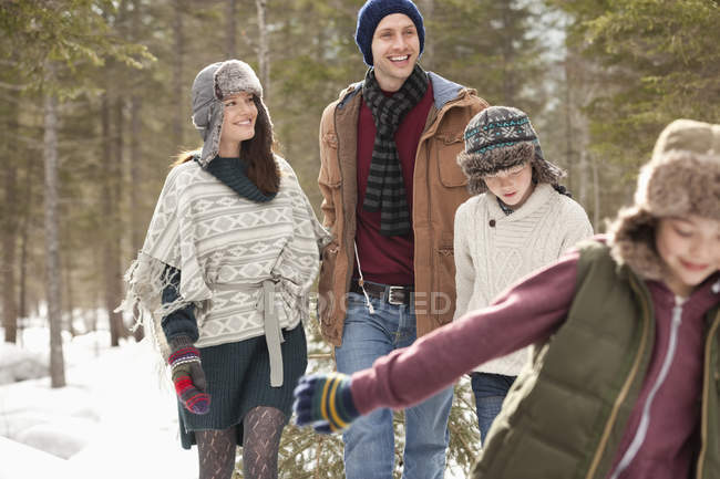 Happy family pulling Christmas tree in snow — Stock Photo