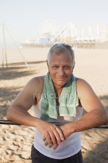 Літній чоловік розслабляється після тренування на пляжі — стокове фото