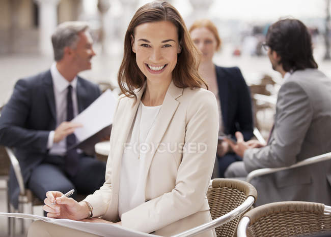 Porträt einer lächelnden Geschäftsfrau, die im Straßencafé arbeitet — Stockfoto