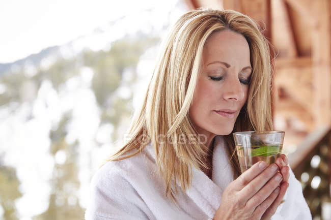 Mulher segurando bebida na varanda da cabine — Fotografia de Stock