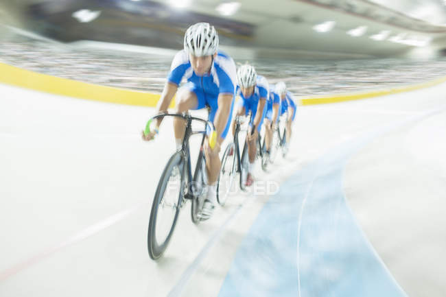 Track cycling team riding around velodrome — Stock Photo