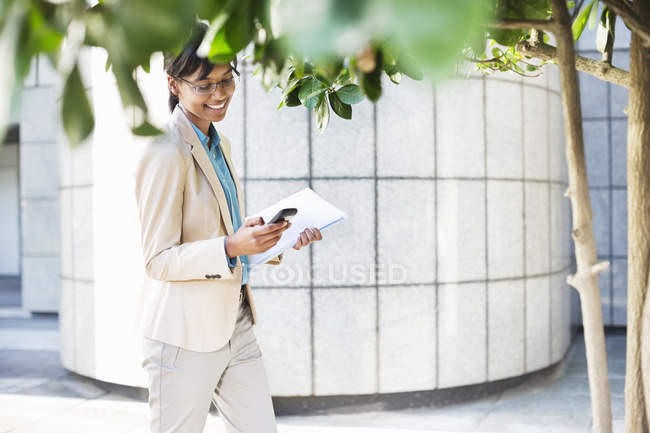 Geschäftsfrau benutzt Handy außerhalb des modernen Büros — Stockfoto