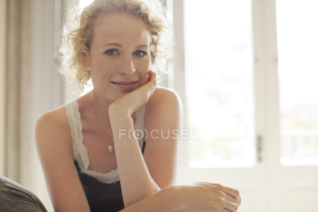 Portrait of smiling woman with head in hands — Stock Photo