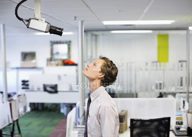 Бізнесмен вивчає камеру безпеки в офісі — стокове фото