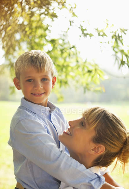 Мать и сын обнимаются в парке — стоковое фото