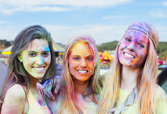 Portrait of smiling women covered in chalk dye at music festival — Stock Photo