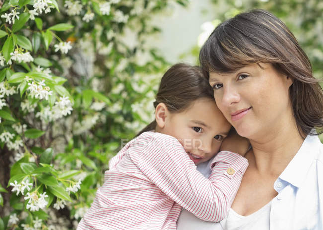 Mother carrying daughter outdoors — Stock Photo