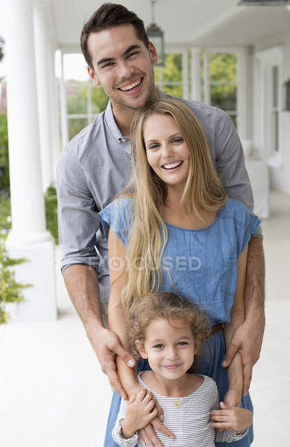 Familia feliz sonriendo juntos en el porche - foto de stock