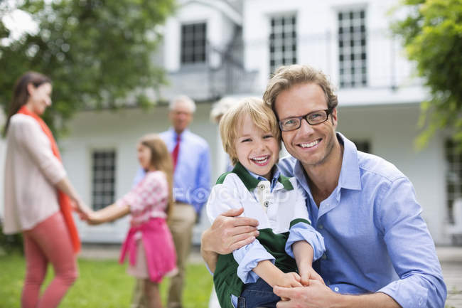 Father and son smiling outside house — Stock Photo