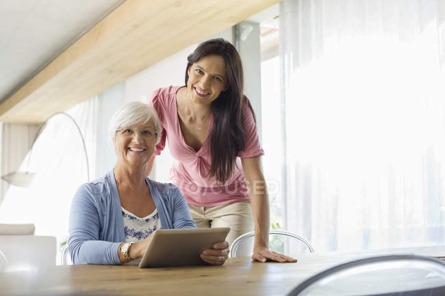 Mulheres usando computador tablet à mesa — Fotografia de Stock