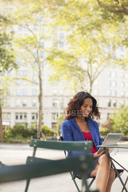 Женщина с цифровым планшетом в кафе на тротуаре — стоковое фото