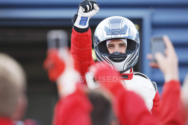 Racer cheering with team on track — Stock Photo