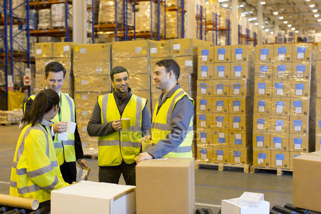 Workers drinking coffee in warehouse — Stock Photo