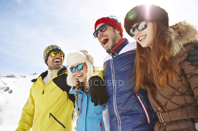 Felici amici caucasici che si abbracciano sulla neve — Foto stock