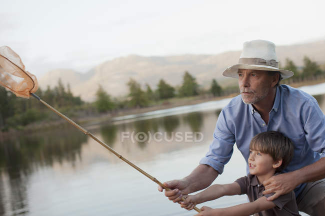 Grandfather and grandson fishing at lake — Stock Photo