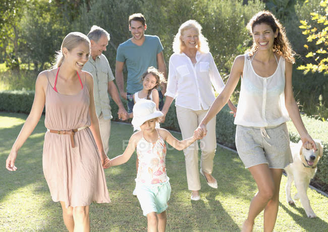 Happy family walking together in backyard — Stock Photo