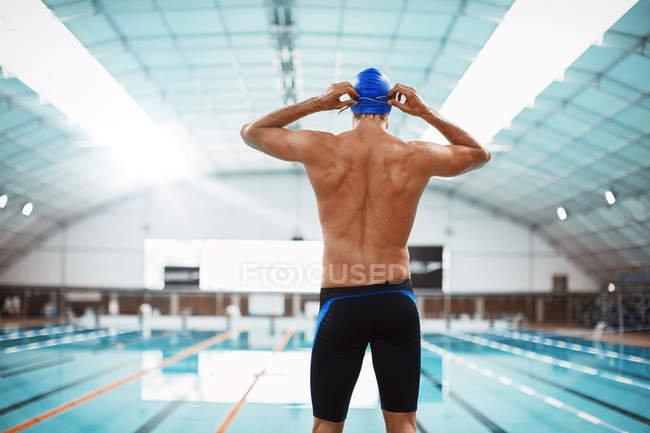Nadador ajustando óculos à beira da piscina — Fotografia de Stock