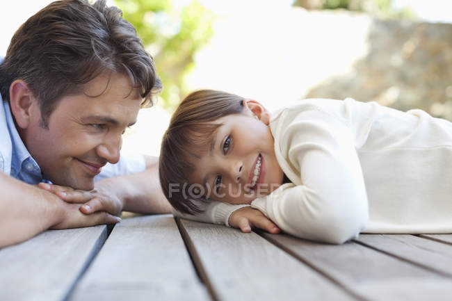 Padre e hija tendidos en el porche - foto de stock