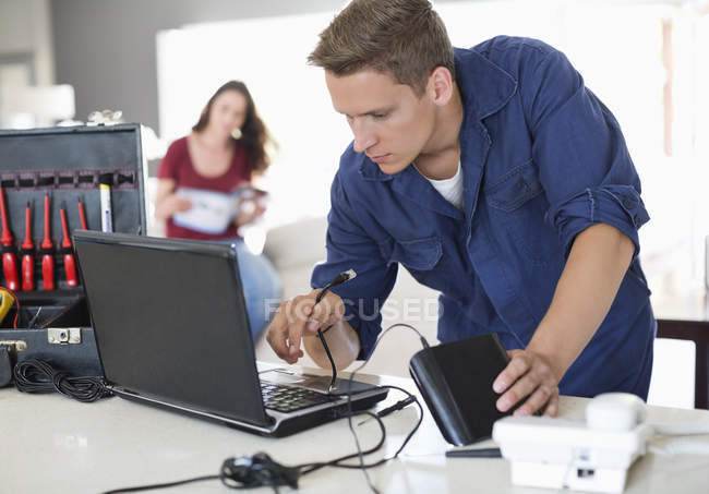 Eletricista caucasiano hábil usando laptop em casa — Fotografia de Stock