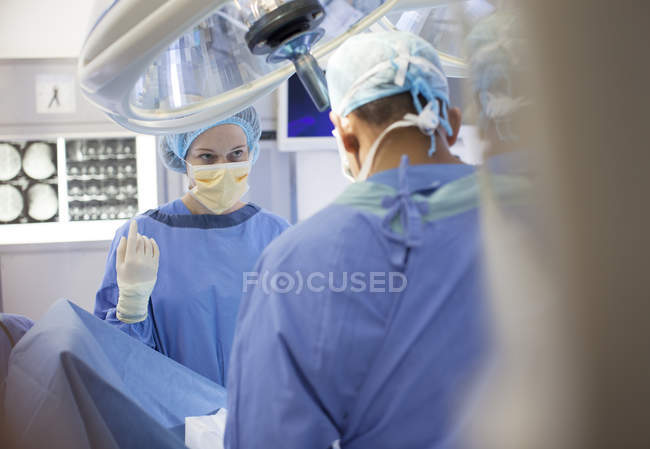 Surgeons standing over patient in operating room — Stock Photo