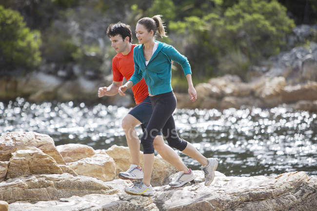 Casal correndo em formações rochosas — Fotografia de Stock