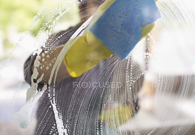 Skillful caucasian man washing window with sponge — Stock Photo