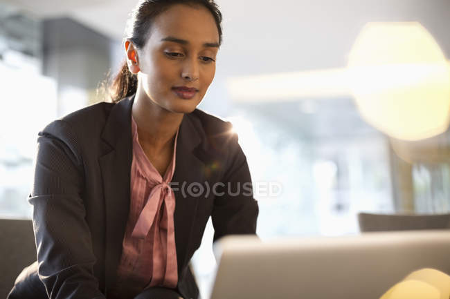 Femme d'affaires utilisant un ordinateur portable au bureau moderne — Photo de stock