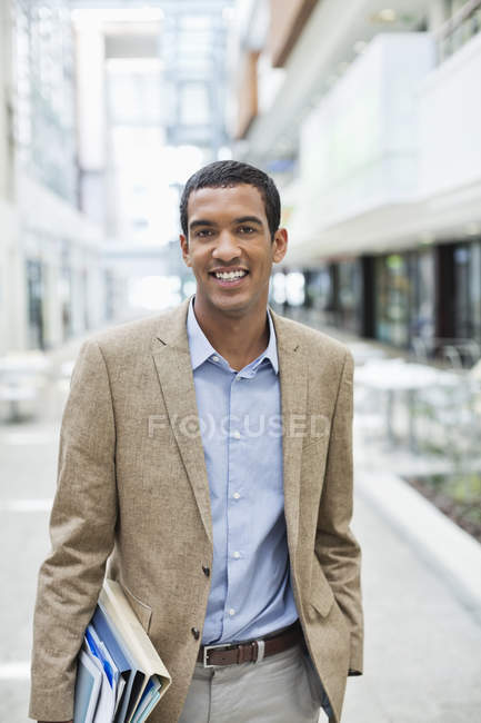 Homme d'affaires noir souriant dans la rue de la ville — Photo de stock