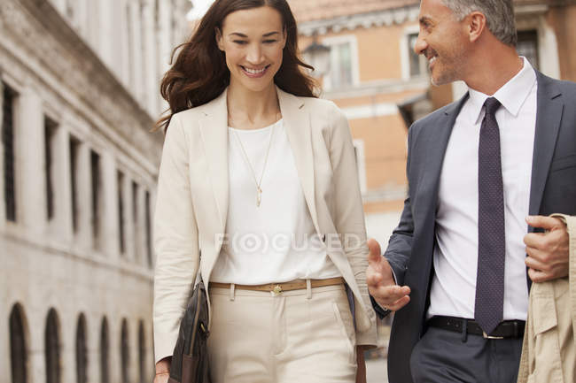 Lächelnder Geschäftsmann und Geschäftsfrau zu Fuß — Stockfoto