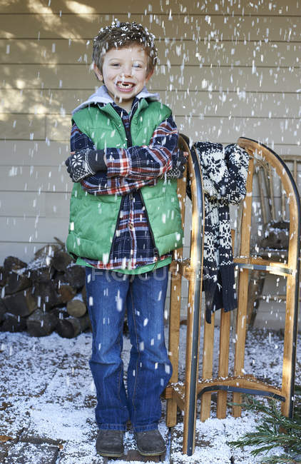 Ragazzo felice caucasico con slitta di legno nella neve — Foto stock