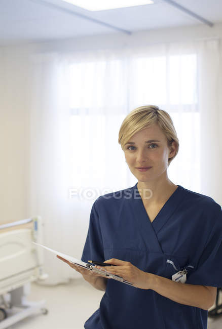 Krankenschwester liest Klemmbrett im Krankenhausflur — Stockfoto