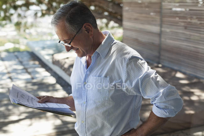 Бизнесмен читает газеты на открытом воздухе — стоковое фото
