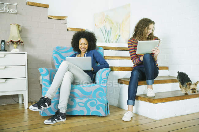 Young happy women relaxing together on steps — Stock Photo