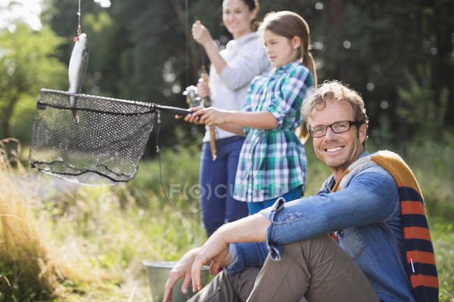 Family fishing together in tall grass — Stock Photo