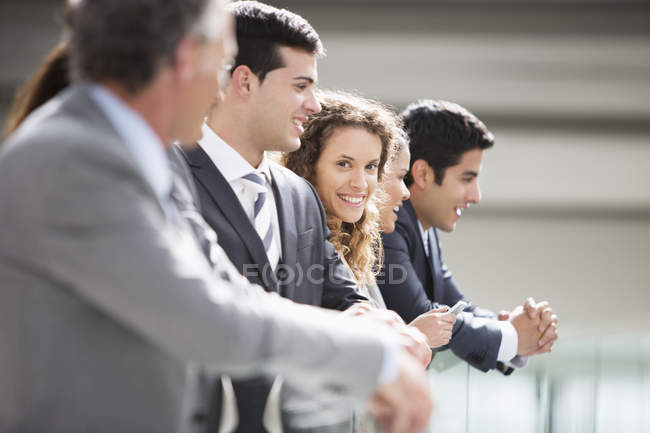 Portrait of confident businesswoman standing with co-workers in a row — Stock Photo
