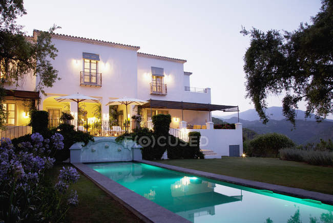 Luxury lap pool and villa at dusk — Stock Photo