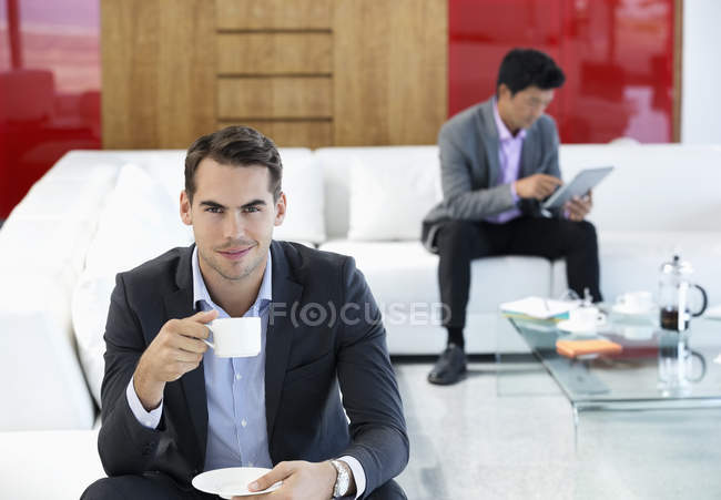 Homme d'affaires ayant une tasse de café au bureau — Photo de stock